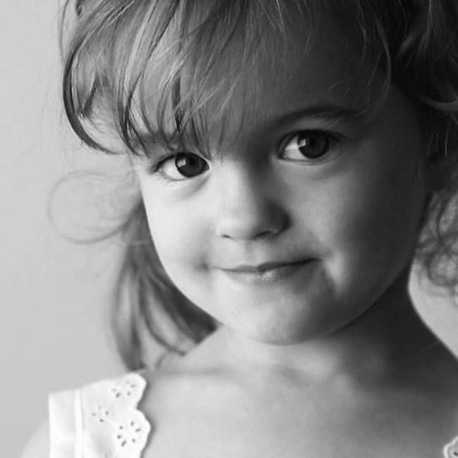 a well lit black and white photo of a little girl