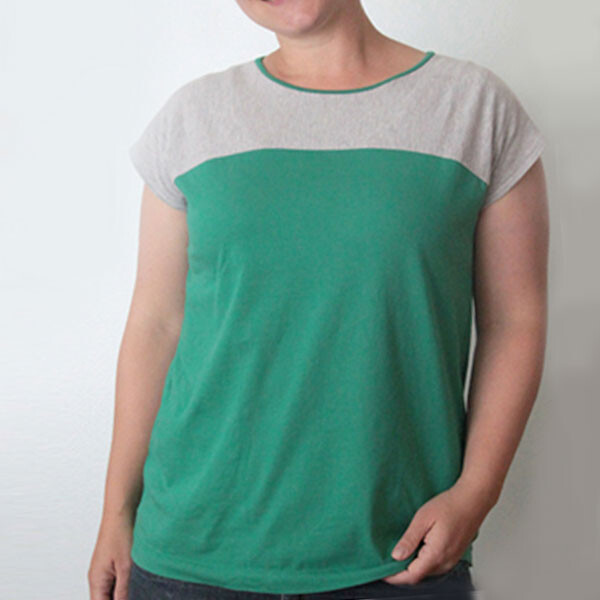 A person in a t-shirt that's grey across chest and shoulders and green on the lower portion