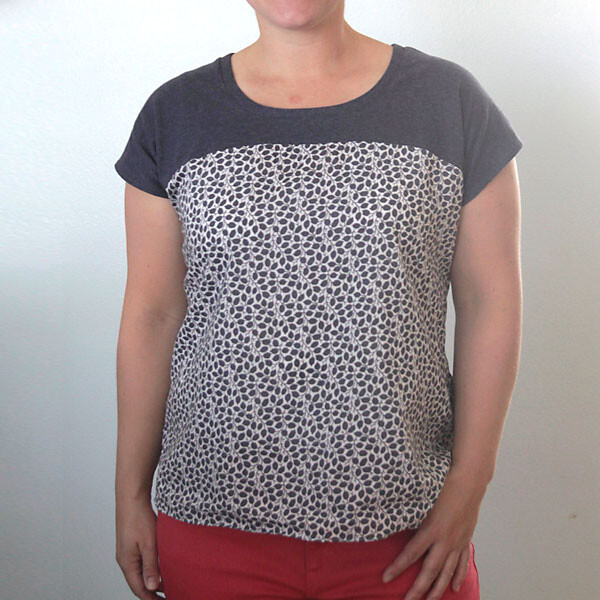 A woman wearing a t-shirt that is solid blue on the shoulders and floral blue on the body of the shirt