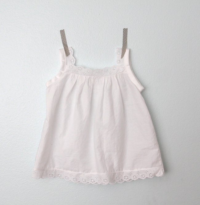 A girls lace trimmed white blouse taped to the wall.