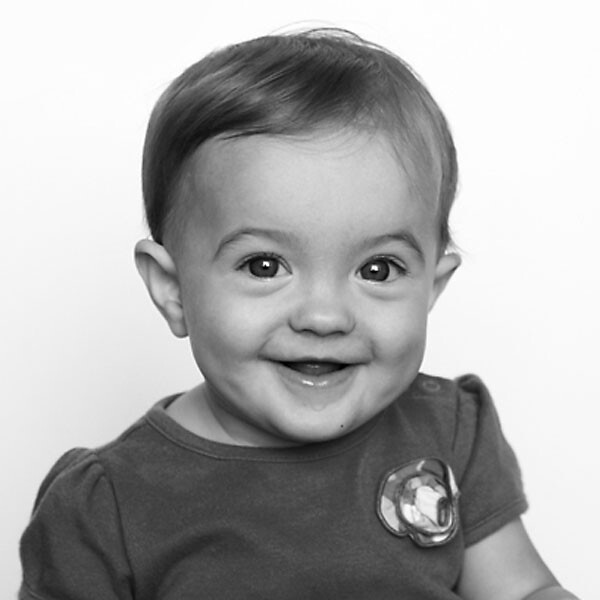 A black and white photo of a baby smiling