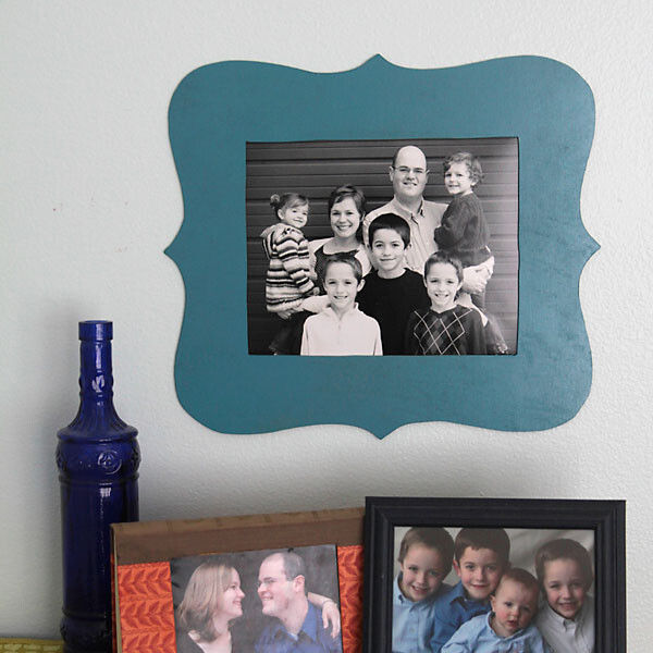 A black and white family photo in a blue scalloped frame