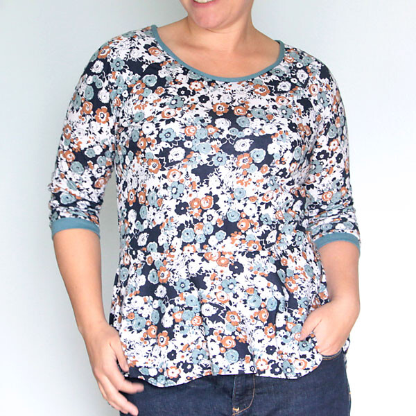 A woman wearing a floral peplum top with long sleeves