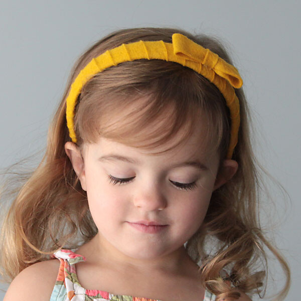 A girl wearing a yellow felt wrapped headband