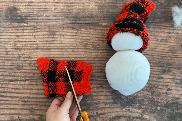 Toe of sock on top of snowman for hat; cutting rest of sock at angle to make scarf
