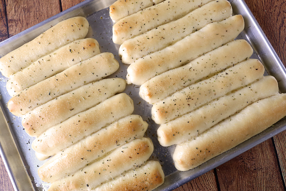 Baking sheet full of garlic breadsticks