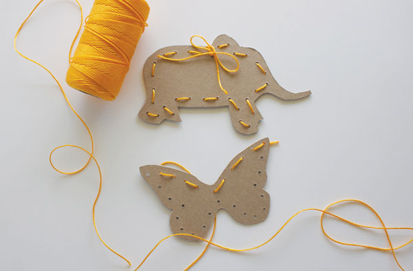 Activity for kids: Cardboard cut in animal shapes with holes around the edges to lace thread through