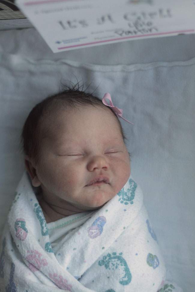 Closeup of newborn baby girl in a bassinet