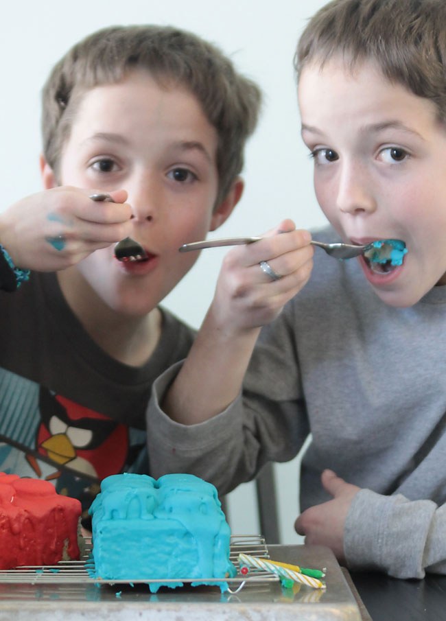 little boys eating a lego cake