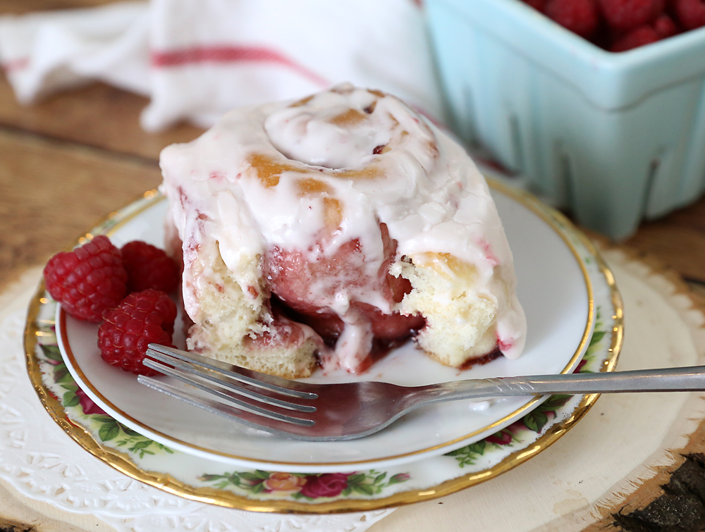 Raspberry sweet roll on a plate with a fork