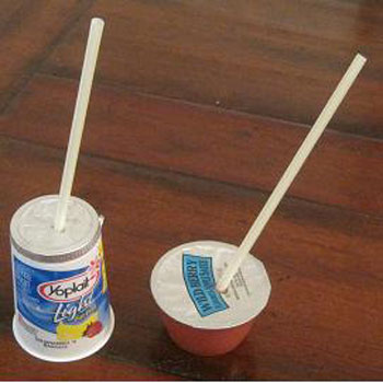 Yogurt container and applesauce container with straws popped through the tops