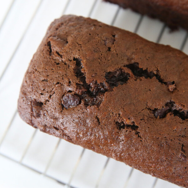 Loaf of chocolate banana bread on a cooling rack.