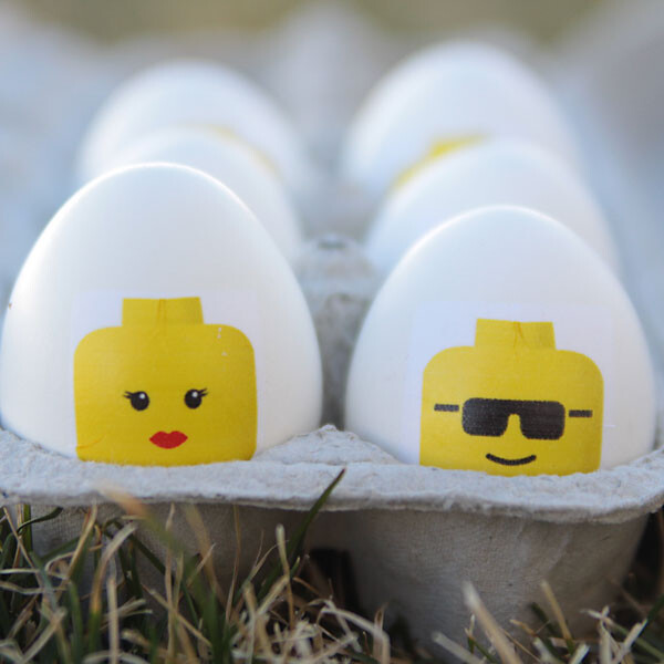 Easter eggs with lego minifig heads on them in a carton