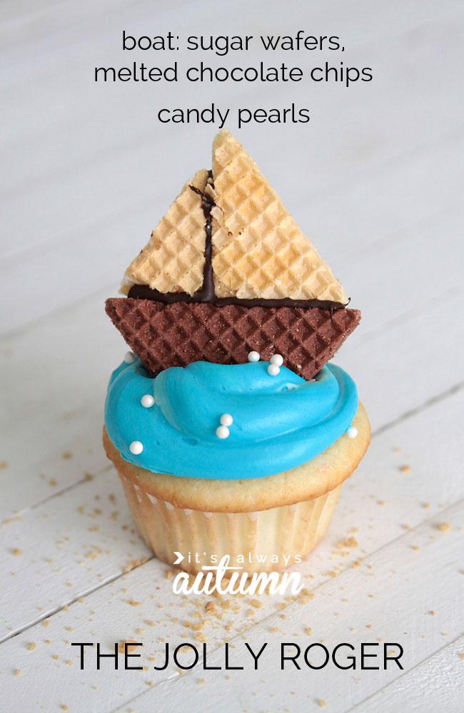 cupcake with blue frosting and ship made from vanilla and chocolate wafers