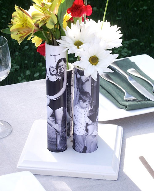 A vase filled with flowers sitting on a table - the vases have photos on them