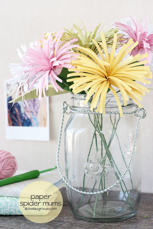 A vase of paper flowers on a table