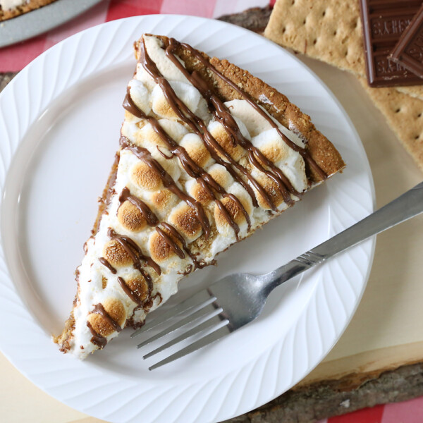 A slice of s'mores pizza on a plate with a fork