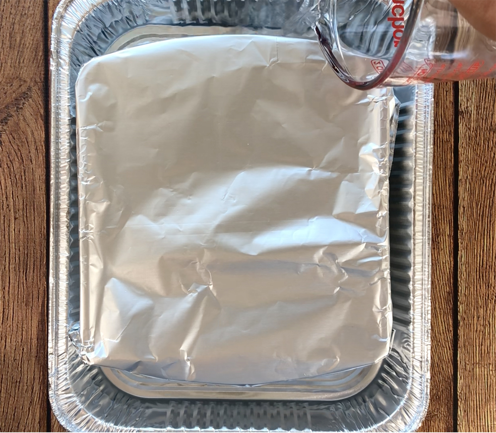 8x8 pan is covered with foil, sitting in a larger pan with water in it