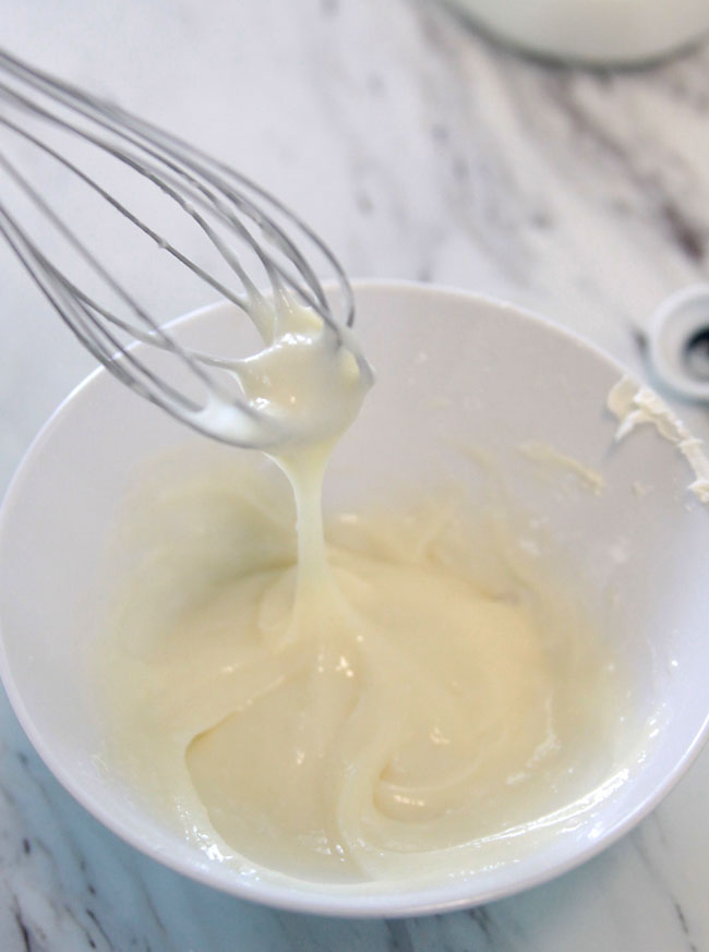 A whisk mixing up cream cheese frosting