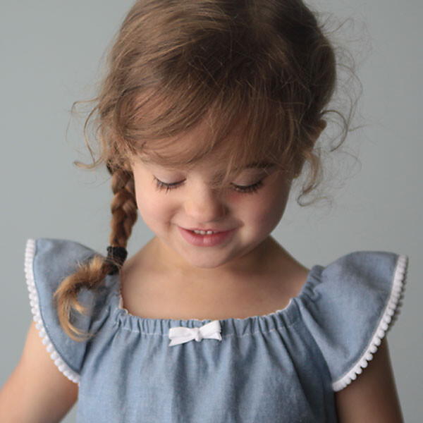 A little girl wearing a flutter sleeve sundress
