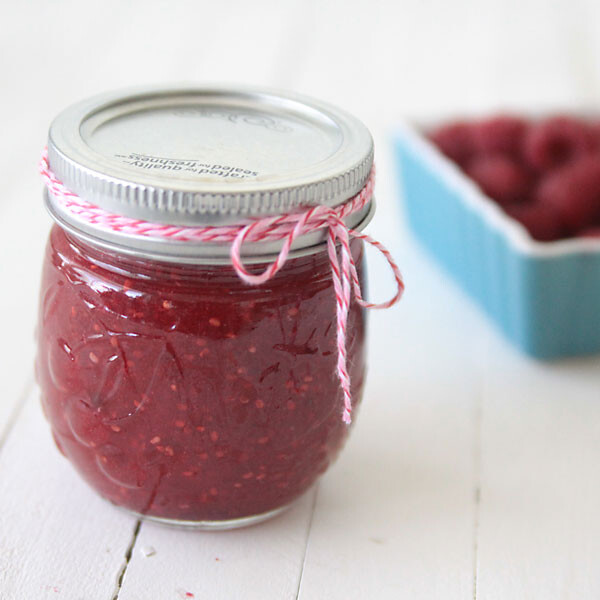 Homemade raspberry jam in a jar tied with twine