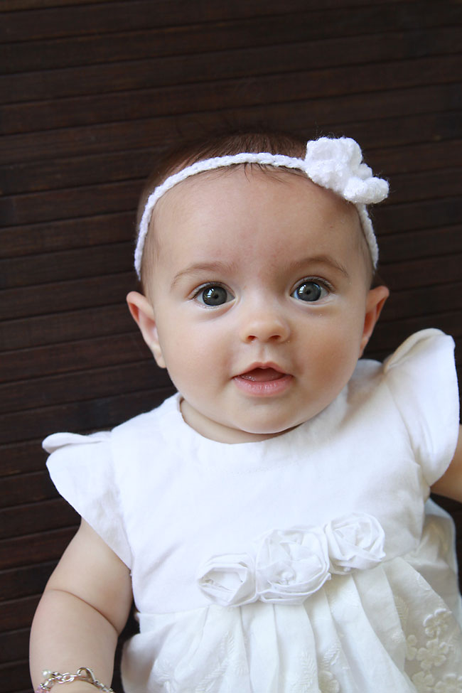 A baby girl lying down with a photo taken from above