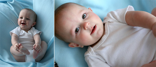 A baby in a white onesie on a blue blanket