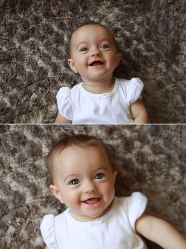 A little girl baby on a blanket laughing