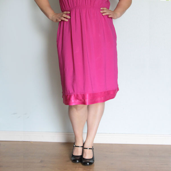 A woman wearing a pink dress that has been made longer using the lining