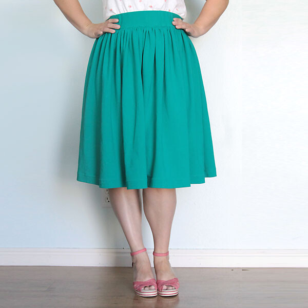 A woman wearing a full green gathered skirt with an elastic waist