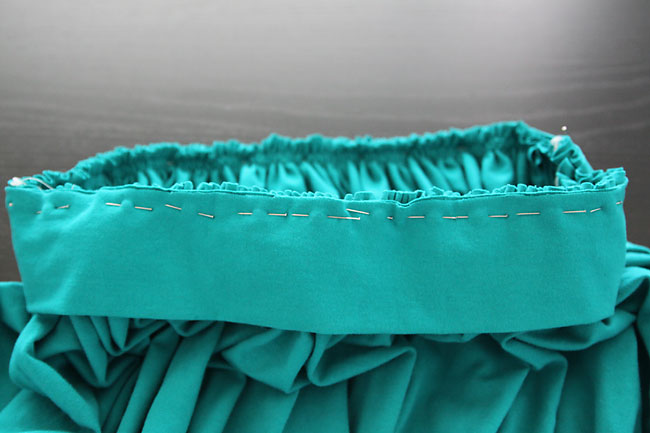 A close up of waistband pinned to a gathered skirt