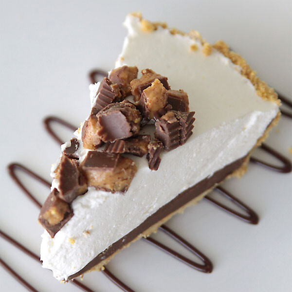 A slice of no bake cheesecake with Reese's cups chopped on top