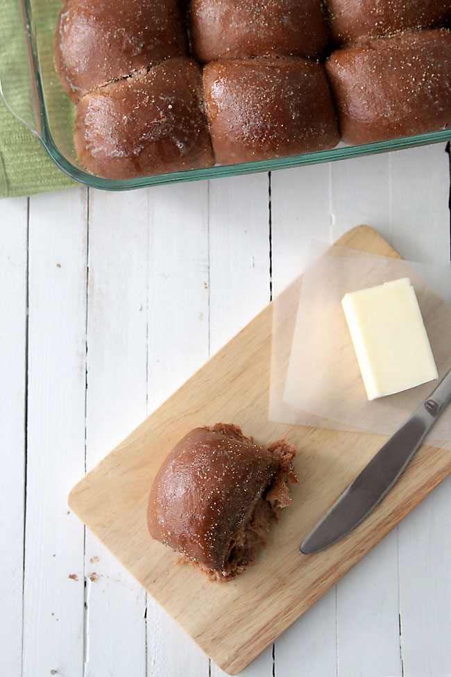 sweet brown roll on a cutting board with knife and butter