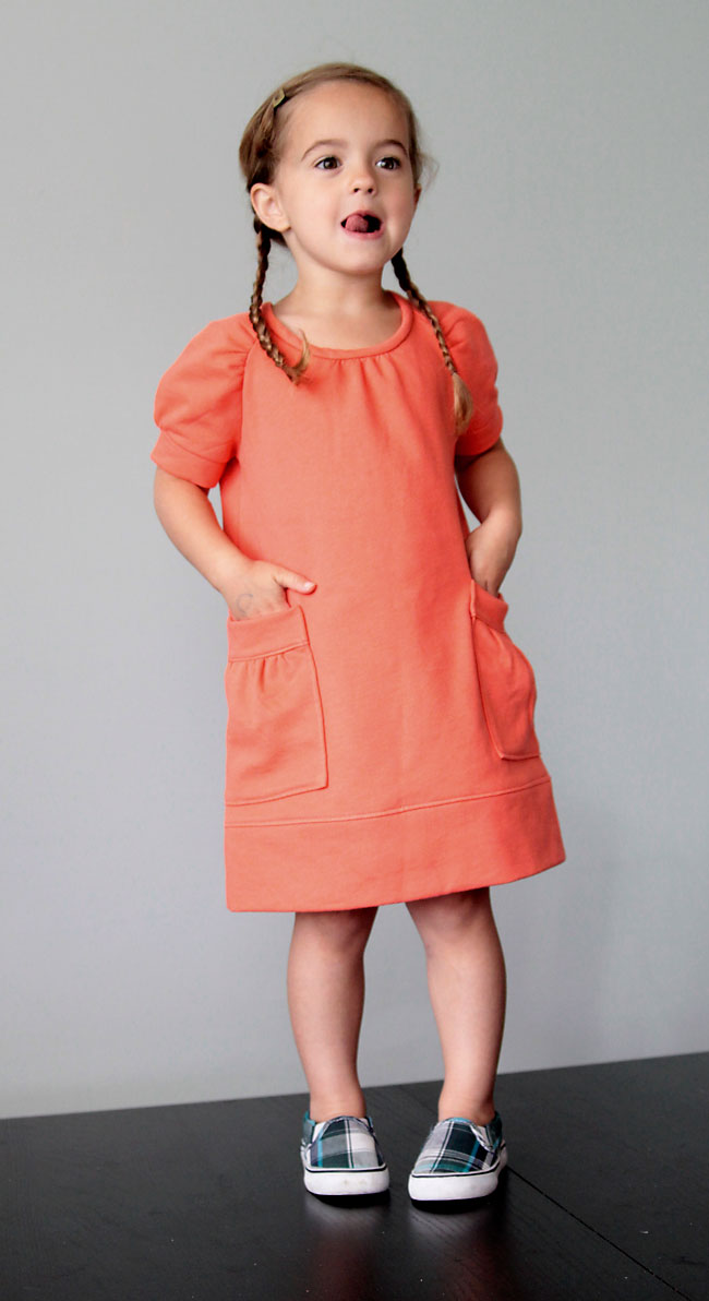 A little girl in a dress with her hands in the pockets