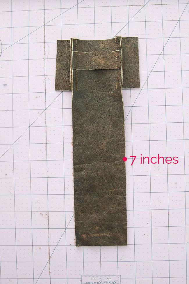 long leather piece with sides sewn on, marked at 7 inches