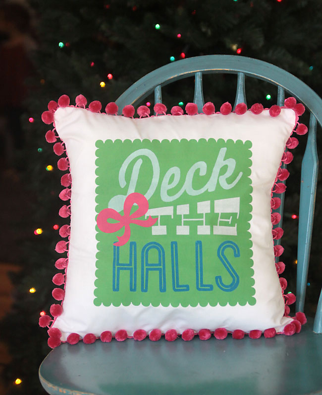 love this deck the halls Christmas pom pom pillow! post explains how to use your silhouette to cut the fabric to make this pillow.