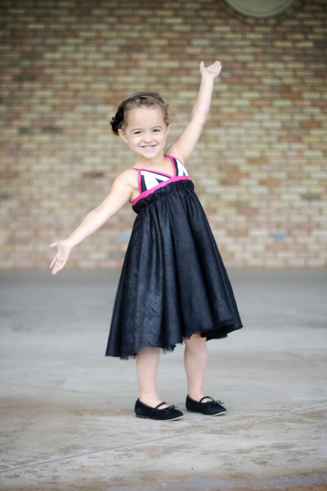 A girl in a black dress with white and pink straps