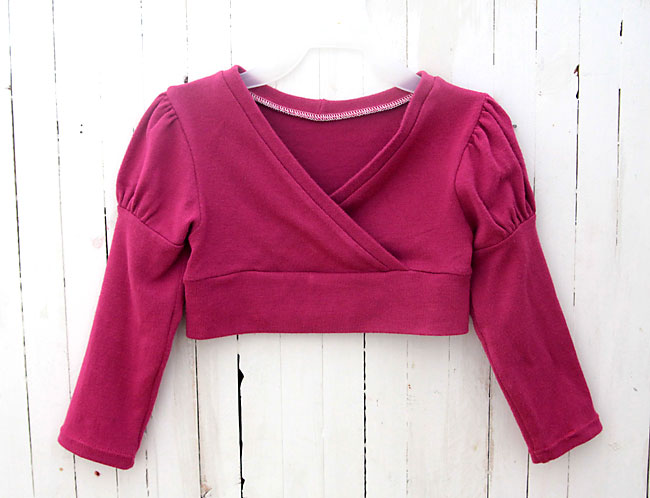 A girls criss cross sweater with puffed princess sleeves