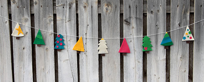 felt christmas tree garland hanging on a fence