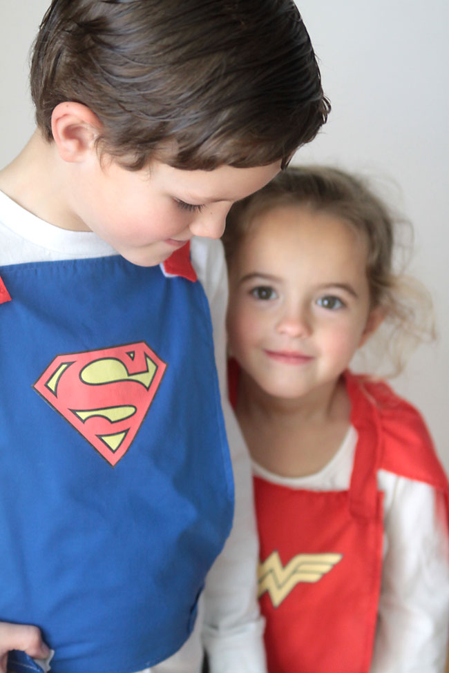 a boy and girl wearing homemade superhero capes