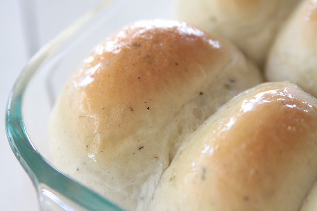 A close up of garlic herb dinner rolls with melted butter on top