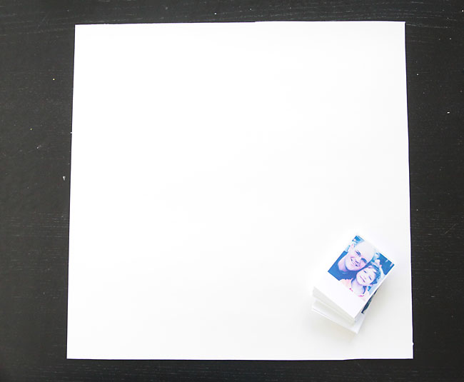 White poster board with stack of photos
