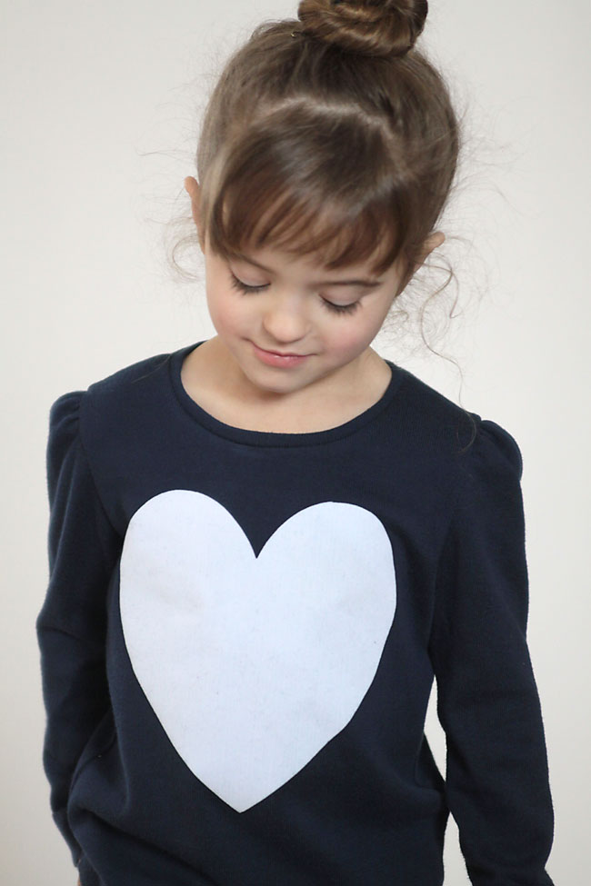 A girl wearing a heart sweater