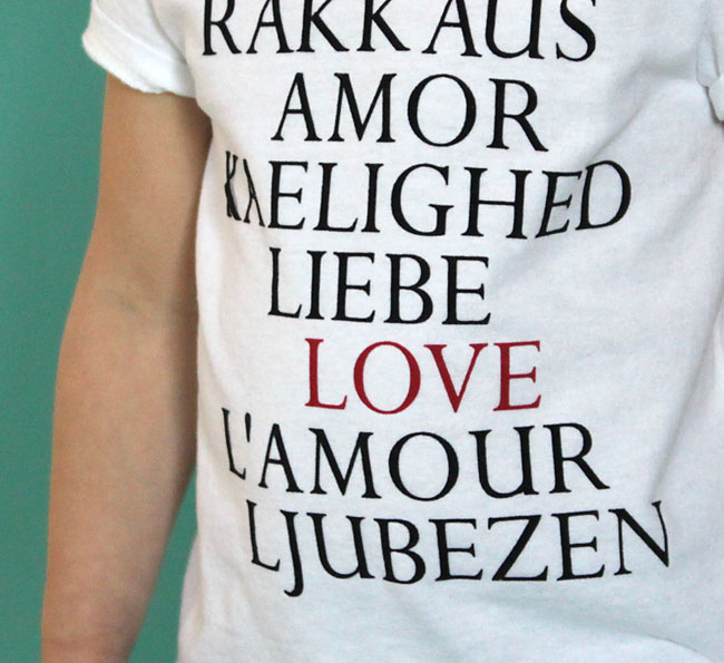 girl wearing a white t-shirt with the word love in different languages on it