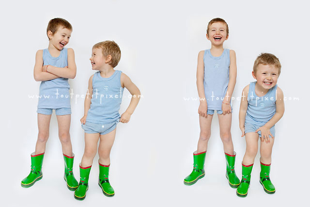 Little boys laughing standing in front of plain white background