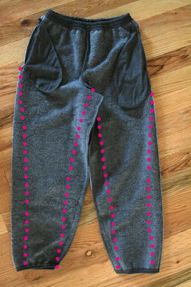 A pair of sweat pants turned inside out, with new seams marked to make a slimmer fit