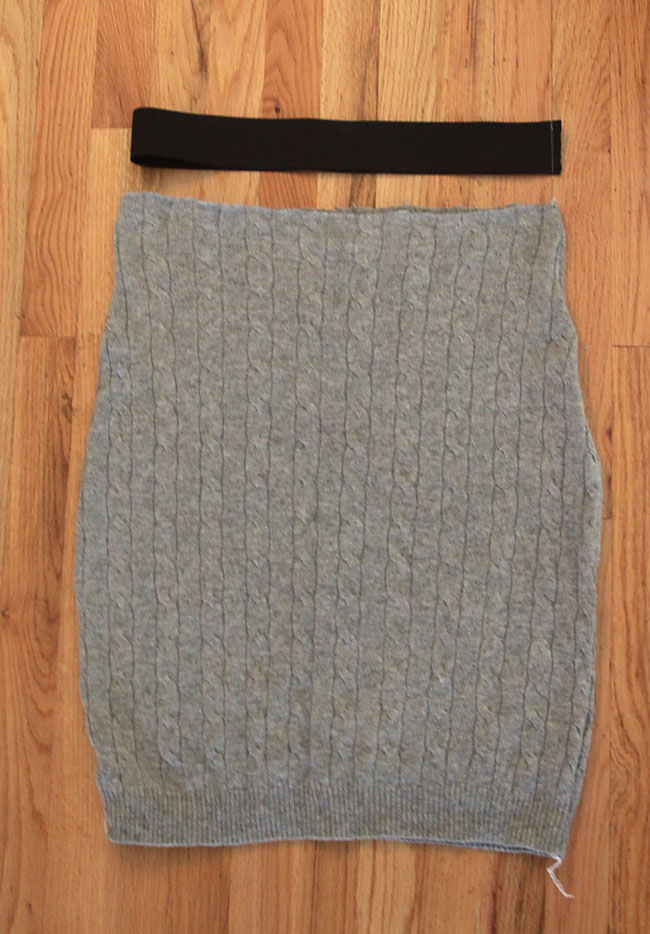 Skirt shape cut from cable knit sweater sewn down the sides, with black elastic waistband