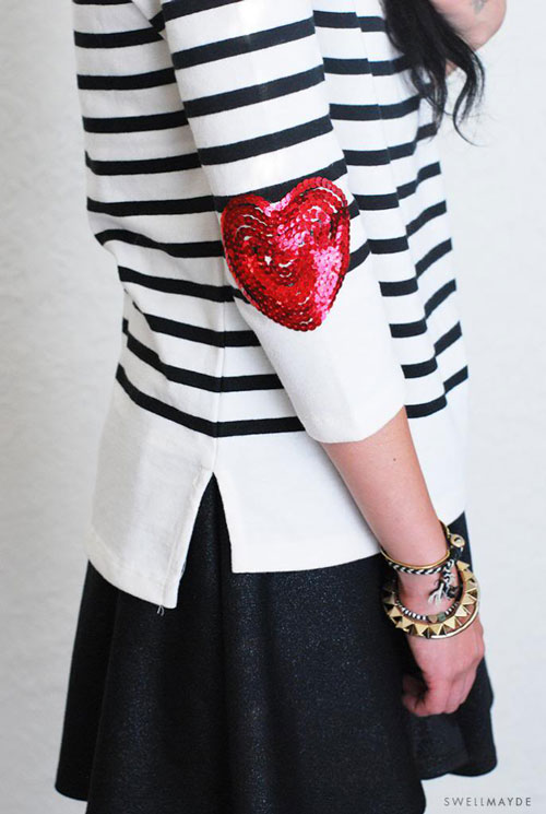 A woman wearing a striped shirt with heart patches on the sleeves