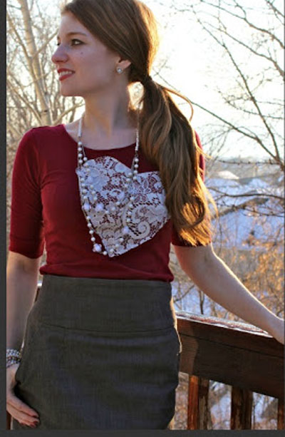 A woman wearing a red shirt with a white heart made from lace on it