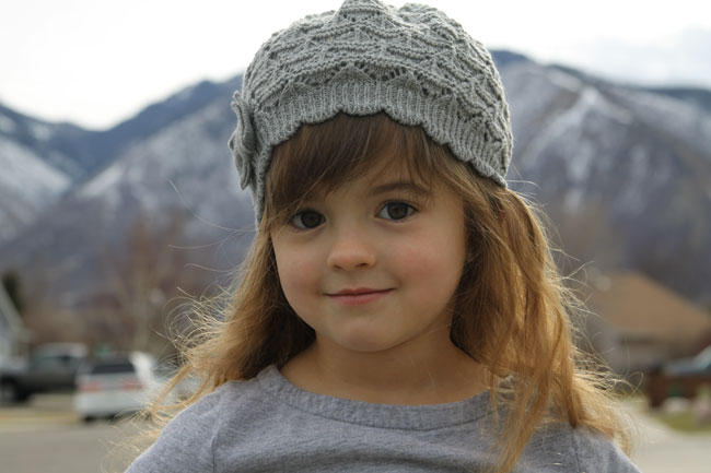 A little girl wearing a hat in a poorly lit photo